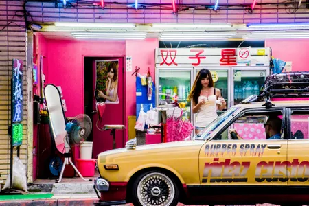 A sidewalk vendor, known as a "betel nut beauty," sells snacks on a curb in New Taipei.