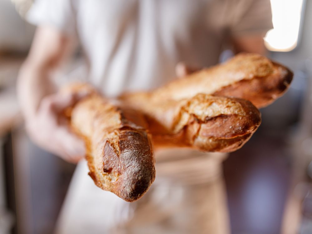 Baker holds baguettes