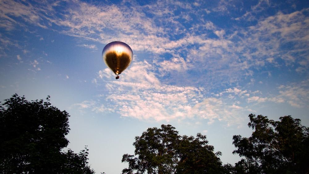 A Giant, Mirrored Hot Air Balloon Is Currently Traveling Over