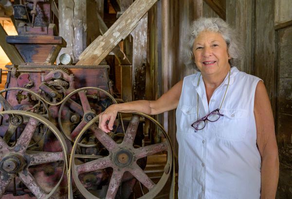 A woman poses in her antique roller mill in rural Virginia thumbnail