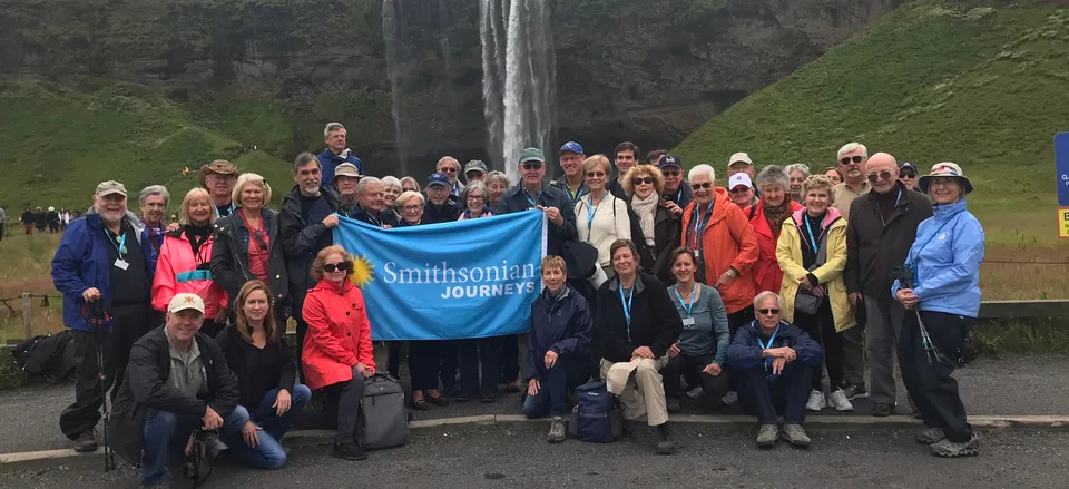 None Smithsonian Journeys travelers in front of the Seljalandsfoss waterfall 