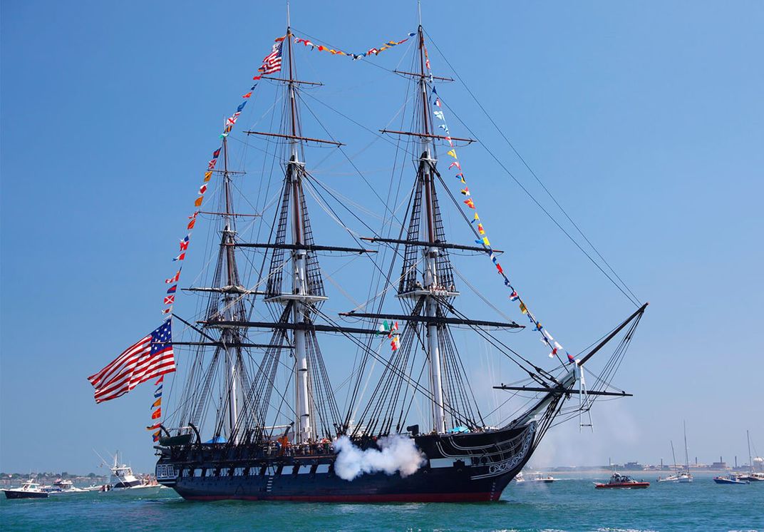 A picture of giant three-mast ship with large U.S. flag on hull