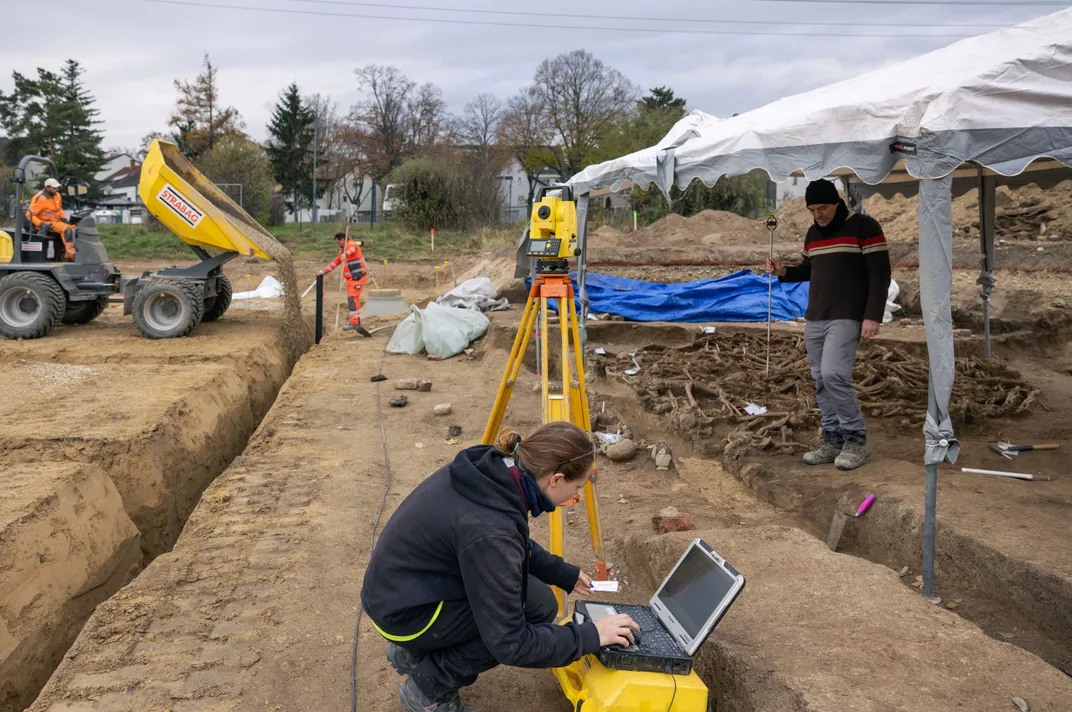 Archaeologists studying human remains at mass grave