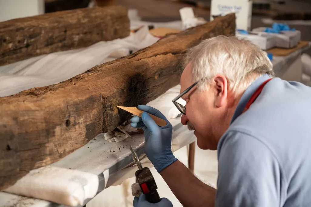 Man using a tool to clean piece of wood