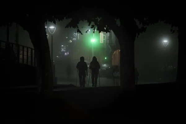 Pilgrims in Fog as a Green Sign Guides a Camino Dawn thumbnail