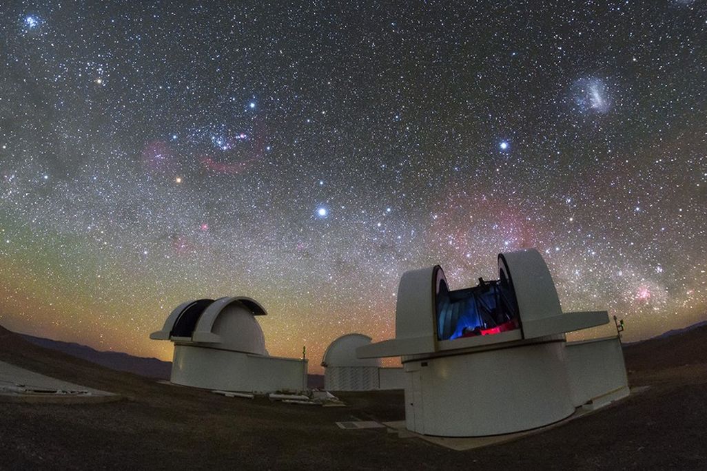 A pair of telescopes in the Atacama Desert in Chile gaze up at a starry night sky.