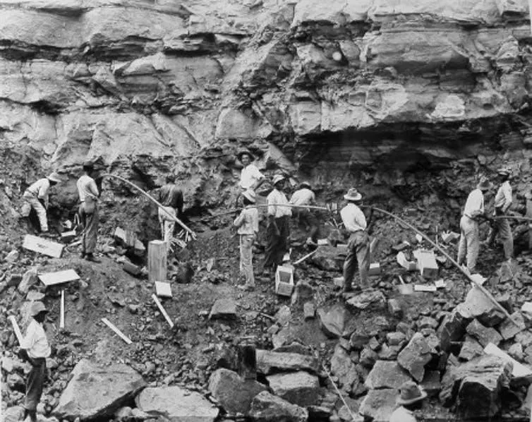 Loading shot holes with dynamite to blast a slide of rock in the west bank of the Culebra Cut, February 1912