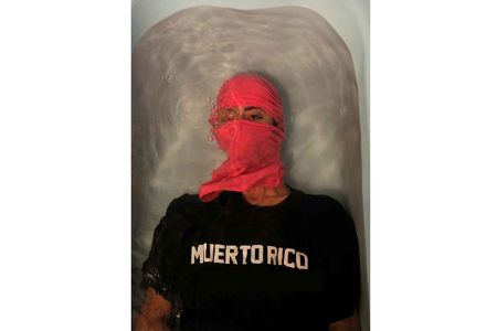 A mask and a wary eye reflects the current conditions of the global pandemic in the  2017 award-winning photograph Muerto Rico by ADÁL.