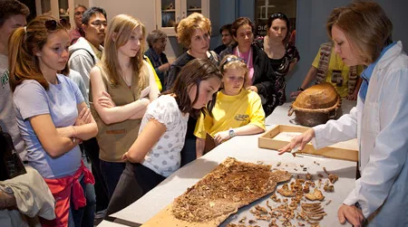 Visitors participating in the "Forensic Friday" event at which a child's cast iron coffin and other skeletal remains from the Richards Family Crypt are analyzed by Dr. Doug Owsley and Kari Bruwelheide. This Friday’s guest is the FBI Explosives Unit