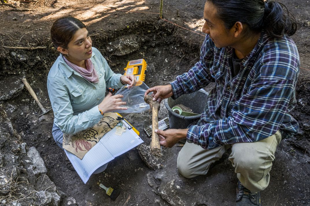 Team members Gabriela Saldaña Tapia and Joel Iglesias recover a human femur to be further studied in the lab.