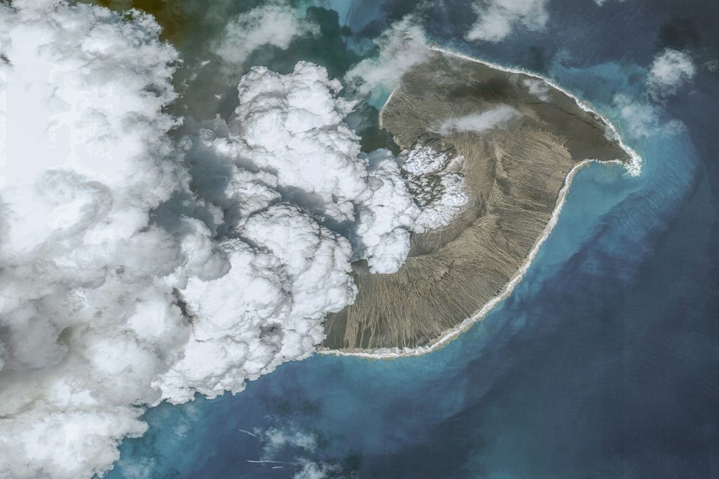 Satellite image of small volcanic island spewing smoke