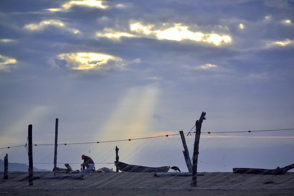 A fisherman mending his nets at sunset. Manabí, Ecuador. thumbnail
