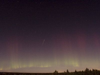 A Draconid meteor streaks across the sky as the northern lights glow, as seen from north of Stockholm on October 8, 2011.