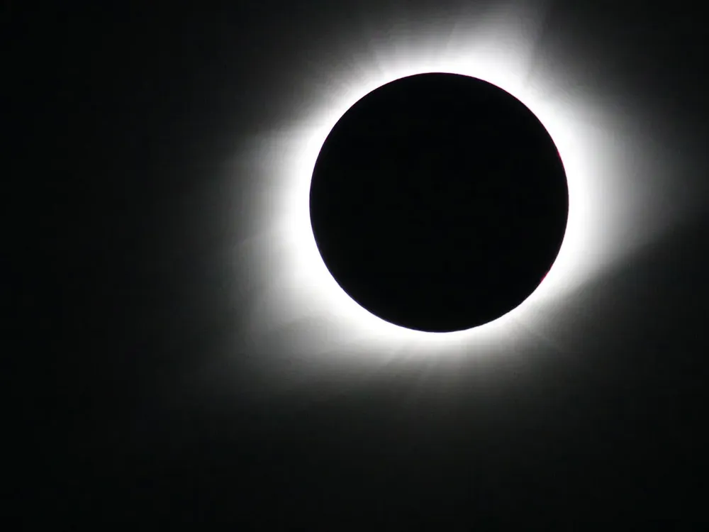Totality during a total solar eclipse, with the moon fully covering the sun and the corona visible