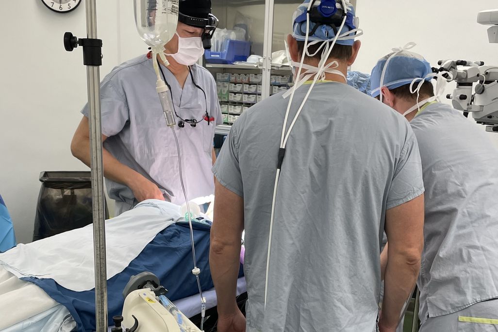 Surgeons standing over a patient in a hospital
