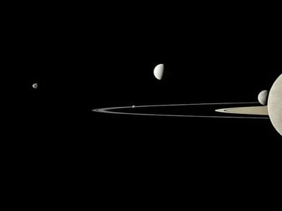 Saturn&#39;s rings and five of its moons, as captured by the Cassini spacecraft in 2011. The five moons, from left to right, are Janus, Pandora, Enceladus, Mimas and Rhea.