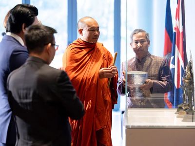 Phin Sokol, the abbot of Khemararangsi Buddhist Temple, performs a Buddhist blessing at a ceremony for the repatriation of three bronze statues that were previously part of the collection of the National Gallery of Australia.