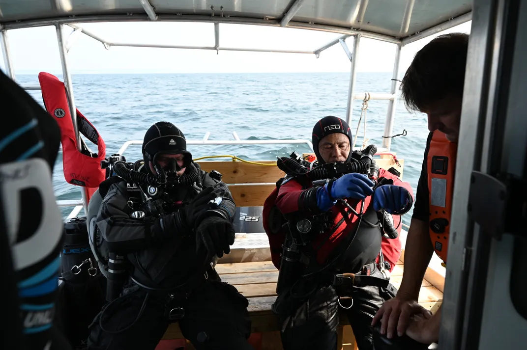 Two men gearing up for a scuba dive on a boat