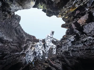 Speleologists in metallurgical &ldquo;cooling suits&rdquo; emerge from the extreme heat of a lava tube formed by the eruption in 2021 of Mount Fagradalsfjall.