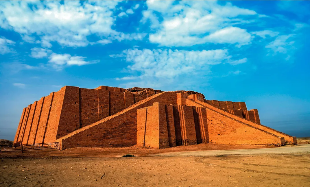 A red stone ziggurat, a stepped tower, surrounded by desert