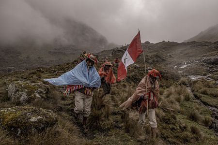 Members of the Quelcanca community in Peru return from planting trees in the mountains, hoisting their country's flag.