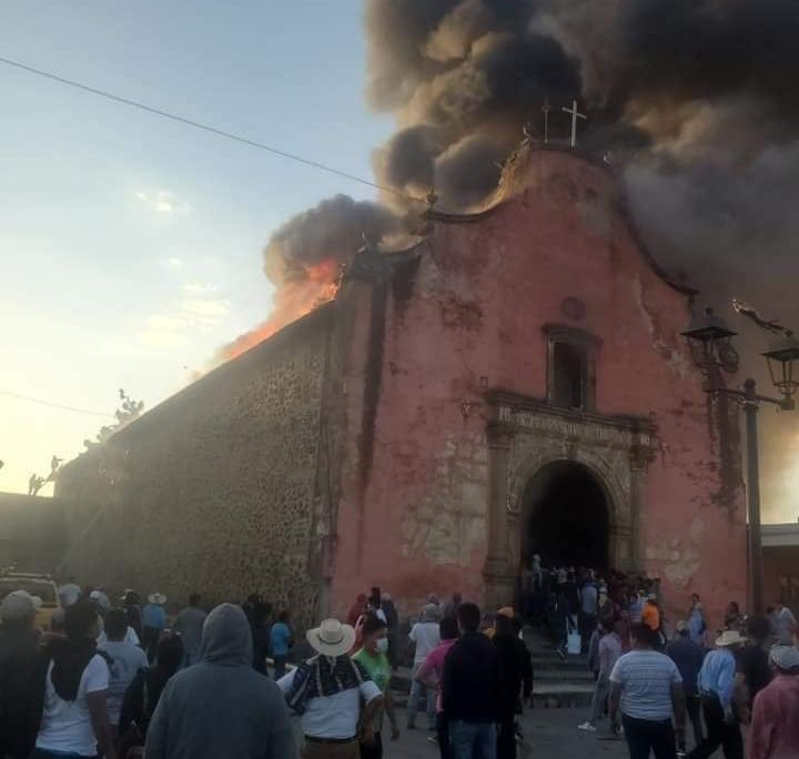 Huge clouds of dark smoke billow from the top of the old, sixteenth-century church