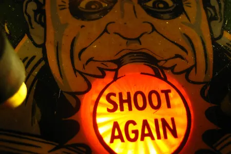 This picture of Uncle Fester holding a lightbulb in his mouth is right above the "gobble hole" at the base of a pinball table.