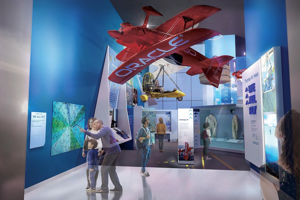 museumgoers under a red Oracle aircraft