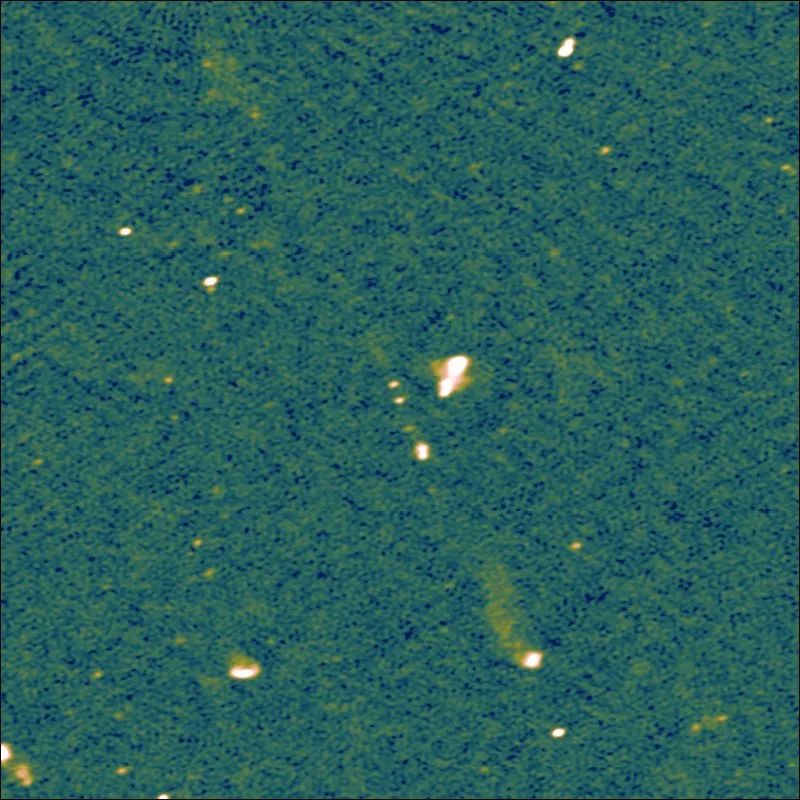 a green and blue fuzzy image with a few yellow specks and a diagonal blurred yellow line