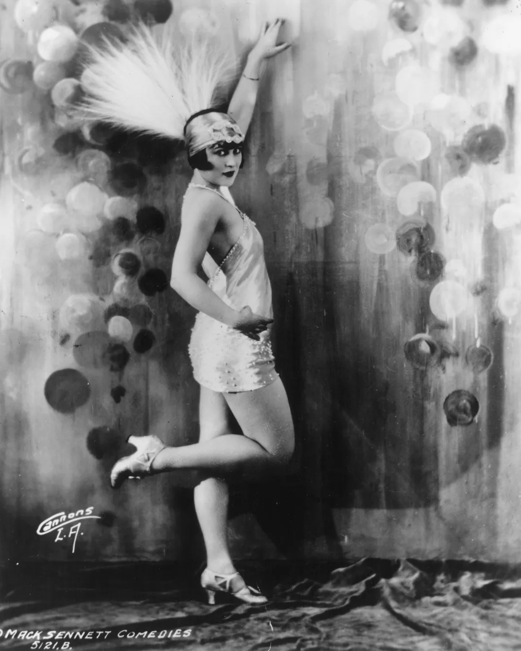 flapper with feathered headress and short dress