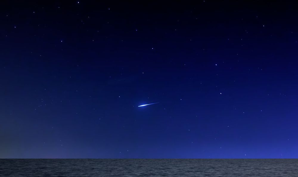 Meteor zipping through dark sky filled with stars