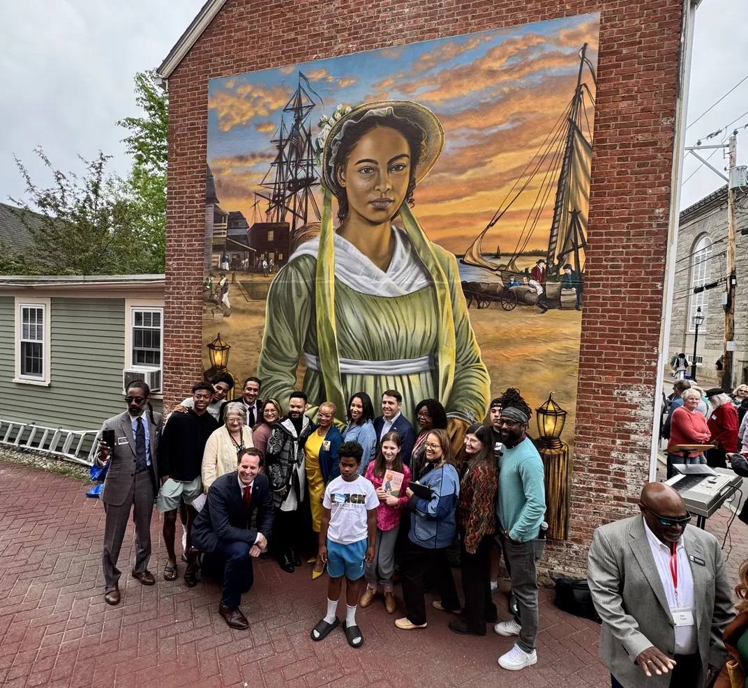 A crowd poses in front of the new Ona Judge mural during the May 23 unveiling ceremony.
