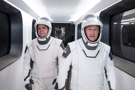 Astronauts Bob Behnken and Doug Hurley walk through Crew Access Arm in SpaceX spacesuits during a dress rehearsal for the first crewed SpaceX launch.