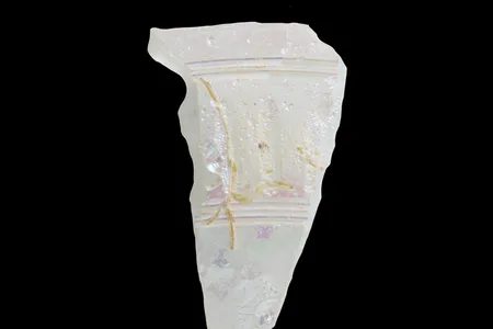 A clear shard of Roman glass found in northern Jordan. The purple highlights are iridescence caused by weathering.
