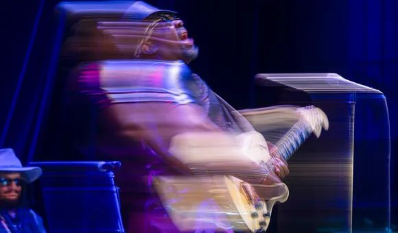 A man on a stage plays a guitar.