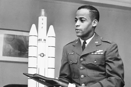 Captain Edward J. Dwight, Jr., the first African American selected as a potential astronaut, looks over a model of Titan rockets in November 1963.