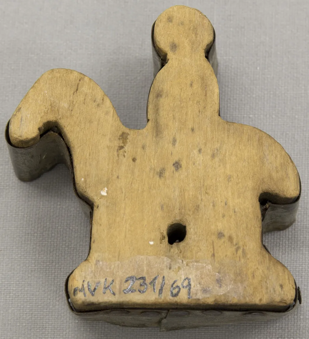 A vintage cookie cutter depicting a person on horseback