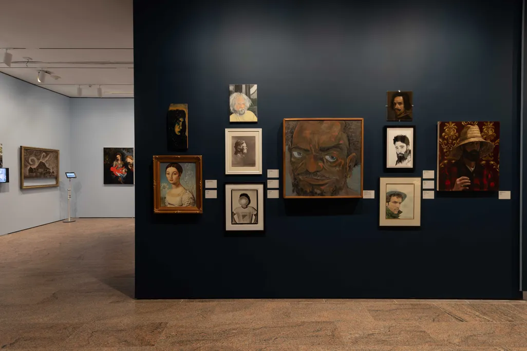 A row of paintings leading to another gallery