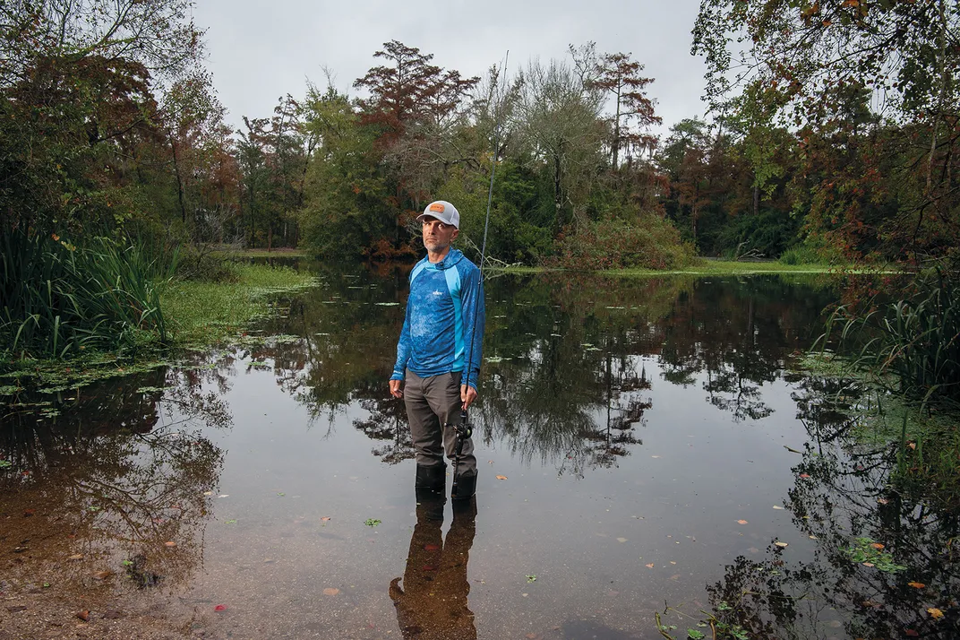 a fisherman stands in a body of water