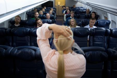 British Airways instructor Diane Pashley demonstrates how to put on an oxygen mask during a flight-safety course at BA’s training facility near Heathrow Airport. Passengers on real flights are often less attentive to safety briefings.