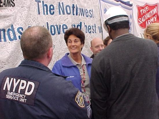 Woman with short brown hair smiles in a crowd of uniformed police offices