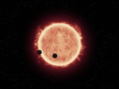 Artist's illustration of the planets, TRAPPIST-1b and TRAPPIST-1c, passing in front of their parent star, which is much smaller and cooler than our sun. 