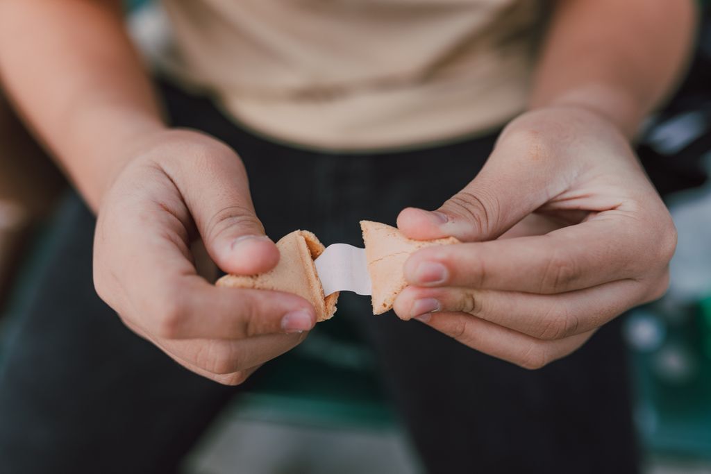 Close-up shot of person opening a fortune cookie