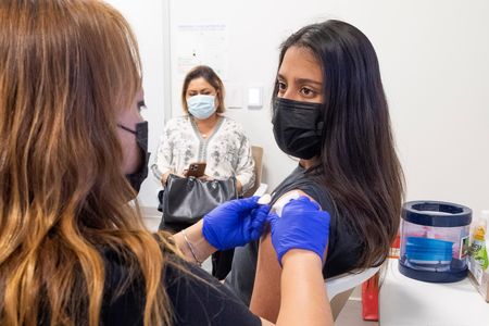 A 16-year-old gets her Pfizer-BioNTech Covid-19 vaccine from a nurse in Anaheim, California, after use for people 16 and older was approved in April.