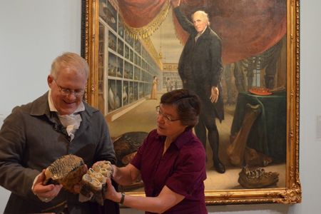 SAAM's Senior Curator Eleanor Jones Harvey and Dean Howarth take a closer look at mastodon bones in the exhibition Alexander von Humboldt and the United States: Art, Nature, and Culture. Charles Willson Peale's painting in the background shows similar bones. Photo by Carol Wilson
