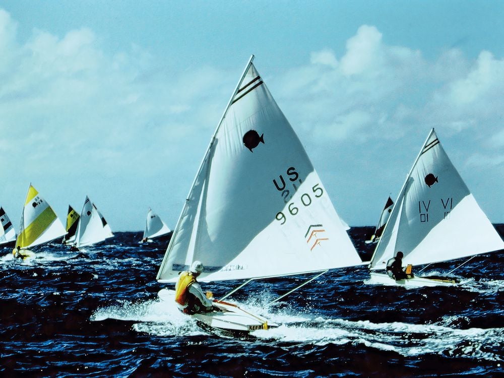 a group of one manned sailboats racing in the ocean