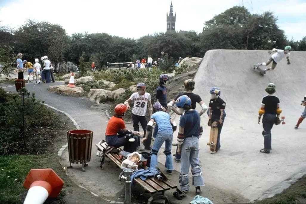 Young people in 1978 wearing helmets and other safety gear skateboarding at Kelvin Wheelies skatepark.