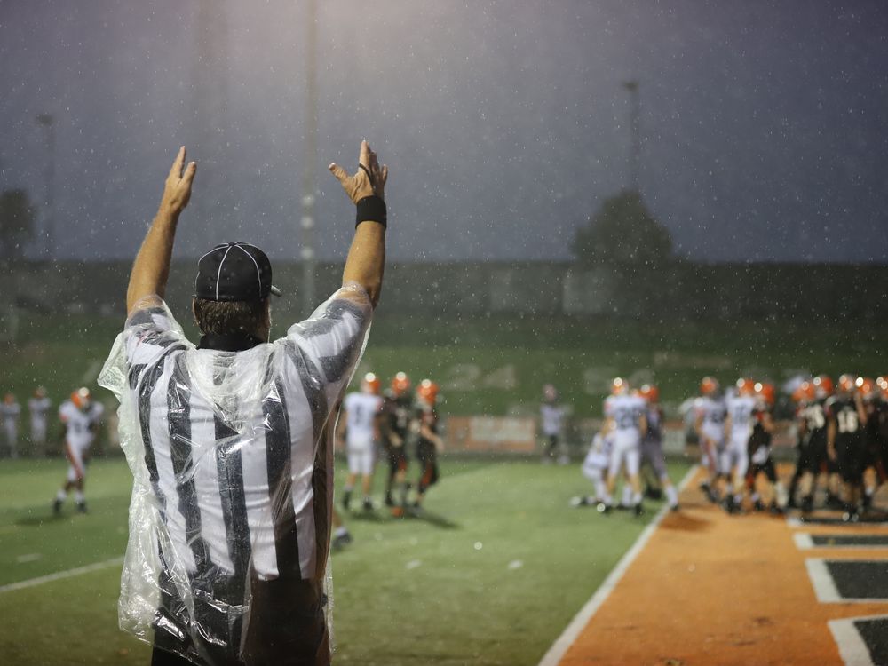 a referee raises his arms to signal a touchdown