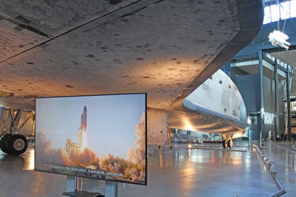 Underneath the space shuttle Discovery as TV monitor shows shuttle liftoff. thumbnail