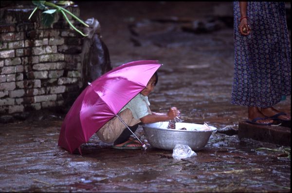 little girl washes clothes using rainy water thumbnail
